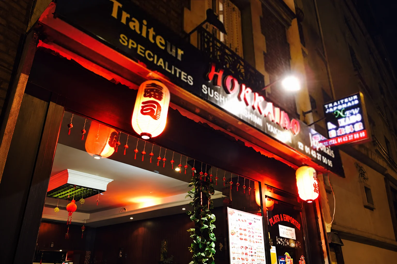 Devanture du restaurant avec l'enseigne Hokkaido et des lanternes rouges, le soir.